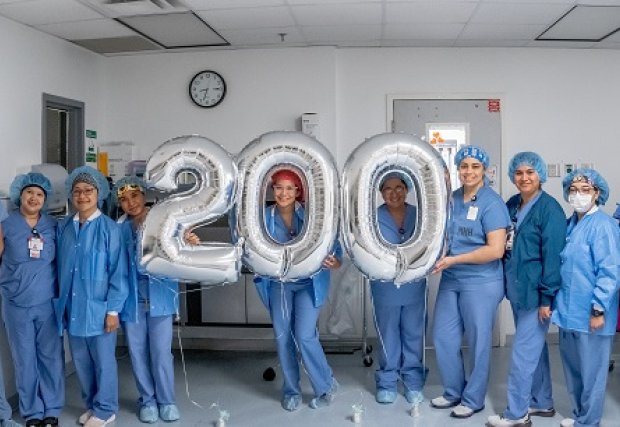 STHS Heart Robotic surgery team holding balloons that spell out '200'.